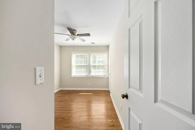 an empty room with wooden floor and a window