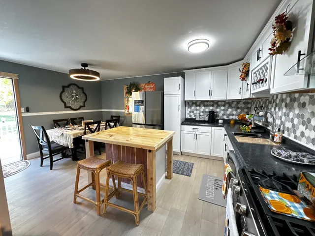 a kitchen with a dining table chairs and white cabinets