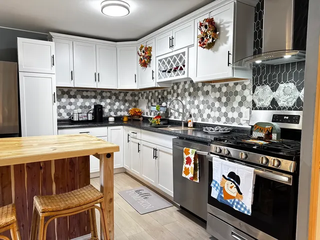 a kitchen with stainless steel appliances granite countertop a stove and a sink
