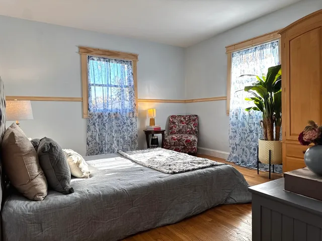 a bedroom with a large bed and a potted plant
