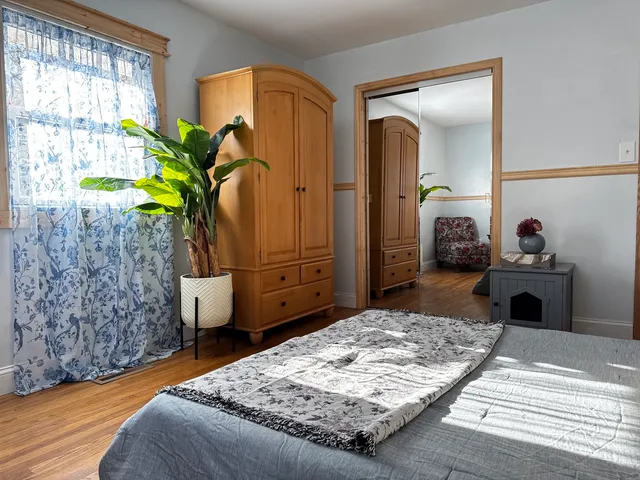 a bedroom with a bed dresser and a window