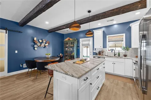 a kitchen with stainless steel appliances granite countertop a kitchen island a stove and a sink