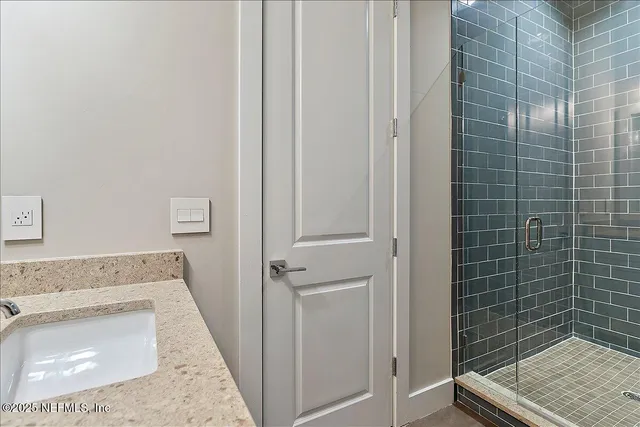 a bathroom with a granite countertop sink a toilet and shower