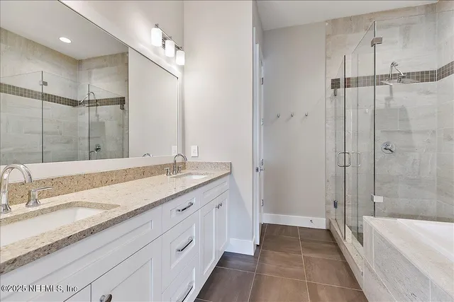 a bathroom with a granite countertop sink mirror bathtub and shower