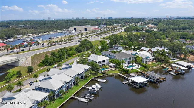 an aerial view of a city with lots of residential buildings ocean and mountain view in back