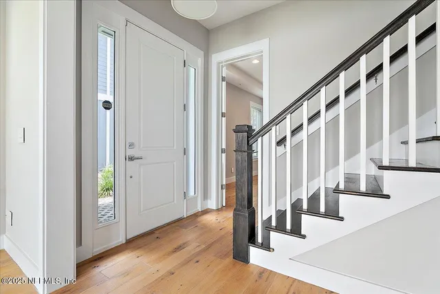 a view of an entryway with wooden floor and door