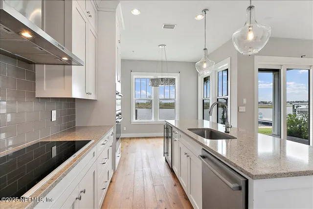 a large kitchen with granite countertop a lot of counter space and a wooden floor