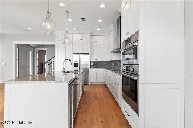 a kitchen with kitchen island a stove a sink and a refrigerator