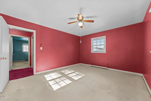 a view of a big room with wooden floor and windows