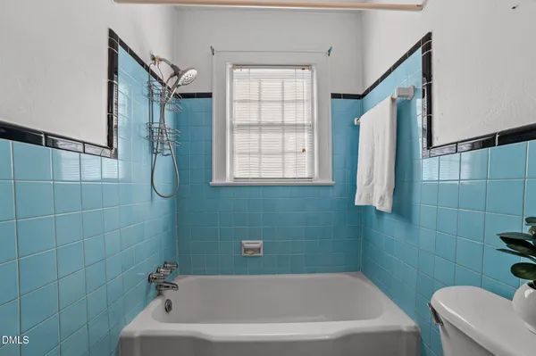 a bathroom with a bathtub a window and a shower