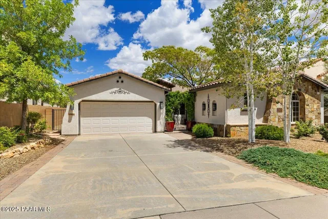 a view of a house with a yard and large tree