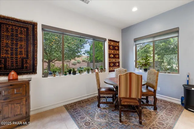 a large kitchen with kitchen island granite countertop a refrigerator a stove a sink a dining table and chairs with wooden floor