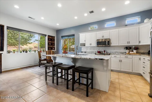 a kitchen with white cabinets and appliances