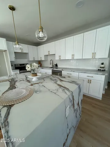 a kitchen with stainless steel appliances granite countertop a sink a stove and cabinets