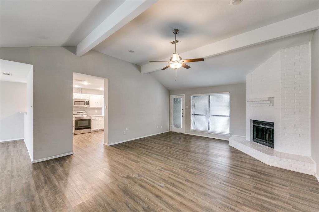 701 Kipling Drive Plano, TX 75023 - Photo 11 of 24 an empty room with wooden floor fireplace and windows