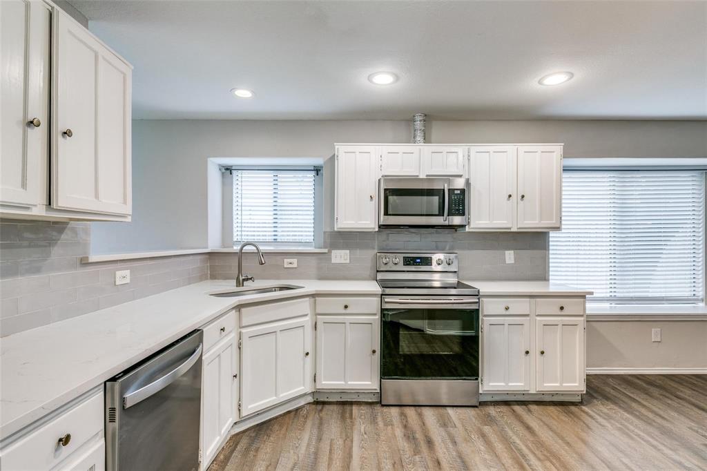 701 Kipling Drive Plano, TX 75023 - Photo 10 of 24 a kitchen with white cabinets stainless steel appliances and sink