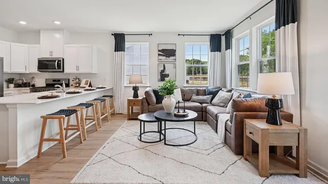 a living room with furniture a flat screen tv and large window