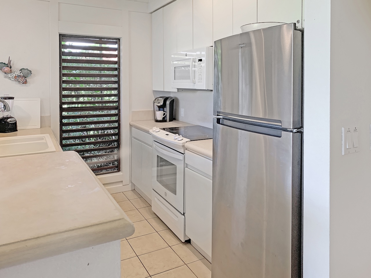 2253 Poipu Road, Unit 28 Koloa, HI 96756 - Photo 5 of 26 a kitchen with stainless steel appliances a refrigerator sink and cabinets