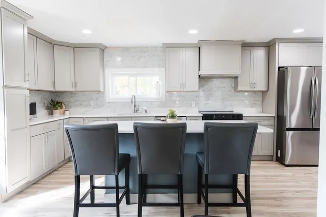a kitchen with a dining table chairs and refrigerator