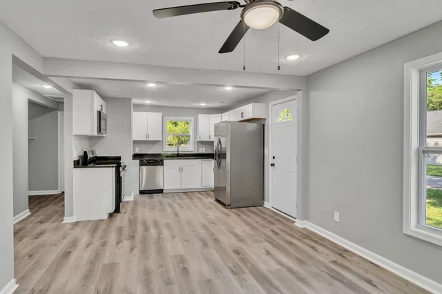 a kitchen with refrigerator cabinets and wooden floor