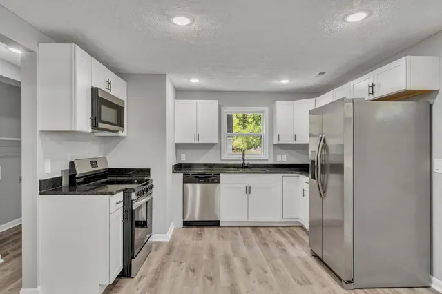 a kitchen with a refrigerator a stove top oven a sink and dishwasher