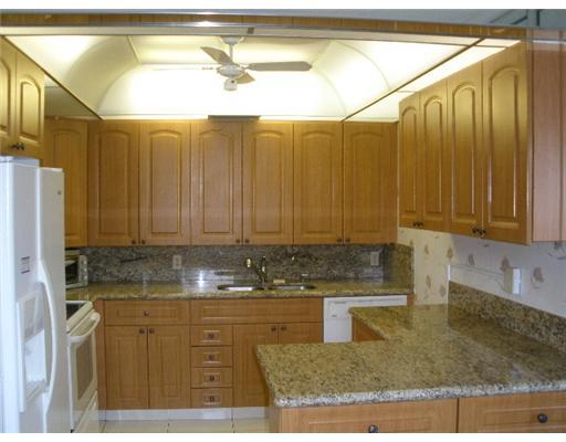 4002 Hythe A, Unit 4002 Boca Raton, FL 33434 - Photo 3 of 10 a kitchen with a sink a counter and cabinets