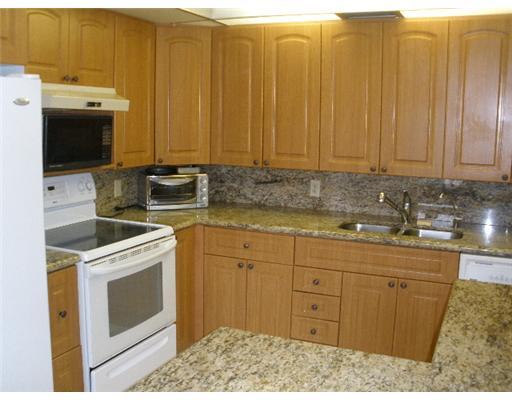 4002 Hythe A, Unit 4002 Boca Raton, FL 33434 - Photo 5 of 10 a kitchen with stainless steel appliances granite countertop a stove a sink and a microwave