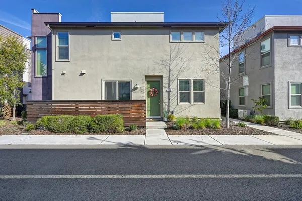 a front view of a house with a yard and potted plants