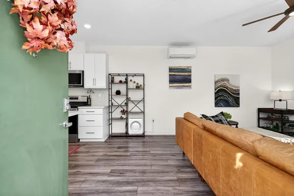 a living room with furniture a flat screen tv and a window