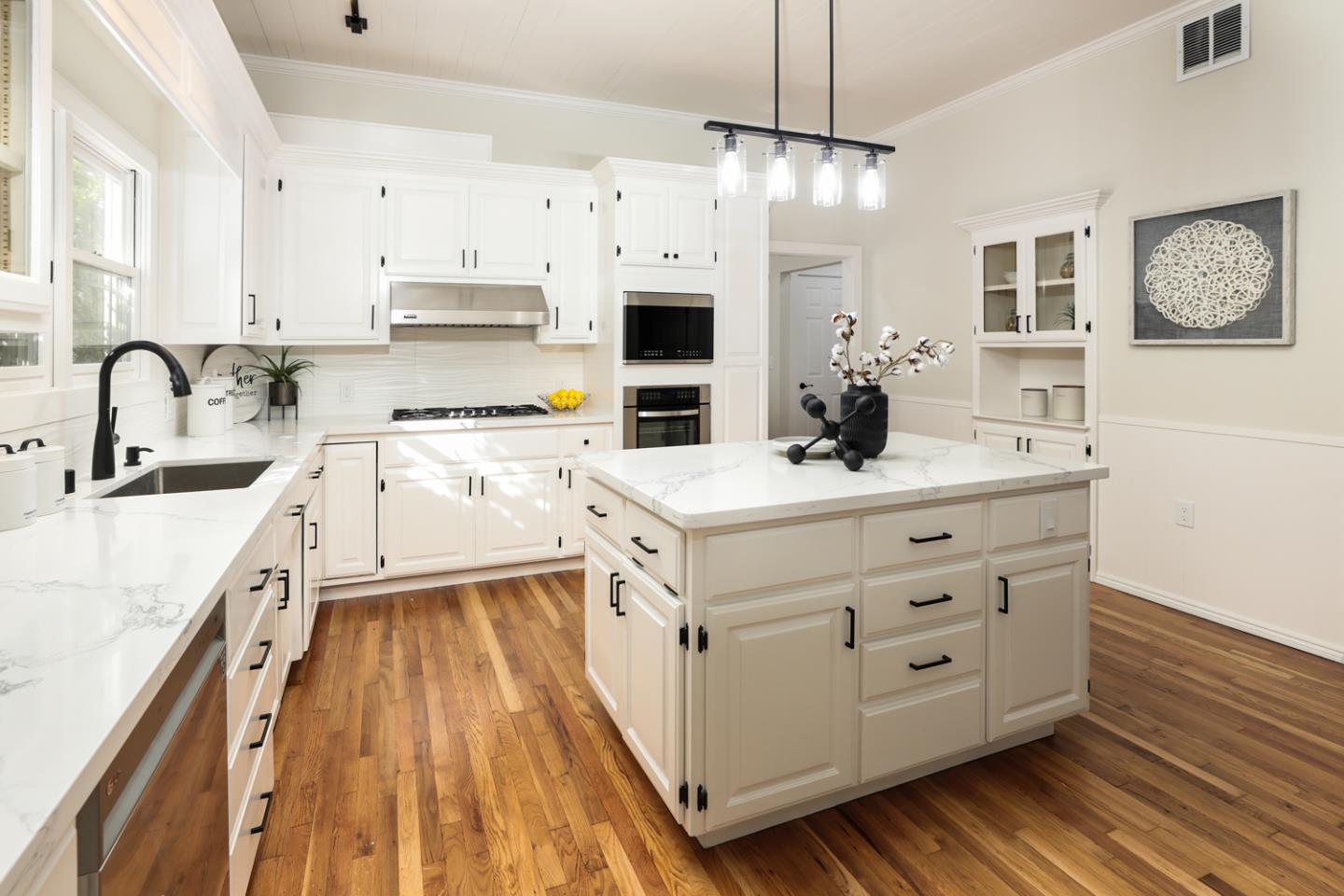 694 Morse Street San Jose, CA 95126 - Photo 11 of 38 a kitchen with stainless steel appliances a white stove top oven a sink dishwasher and white cabinets with wooden floor