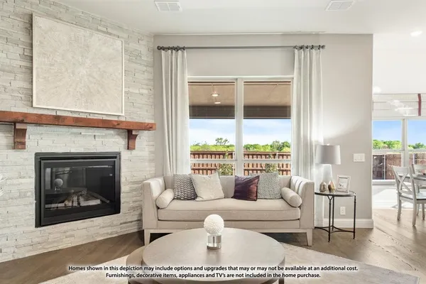 a living room with furniture a large window and a fireplace