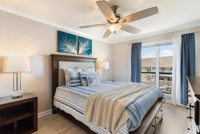 a bedroom with a large bed a chandelier and a dresser