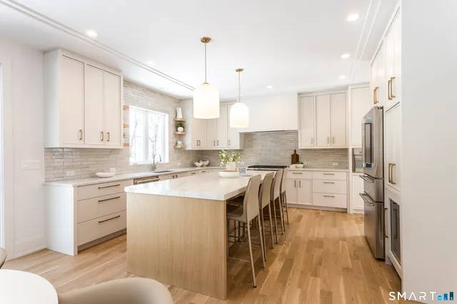 a kitchen with stainless steel appliances a refrigerator sink and cabinets