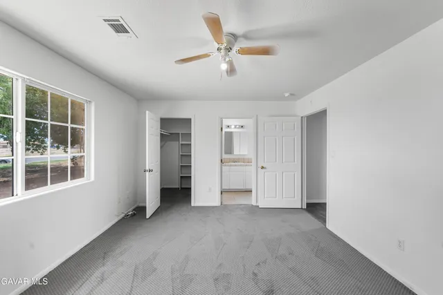 a view of a livingroom with a ceiling fan and window