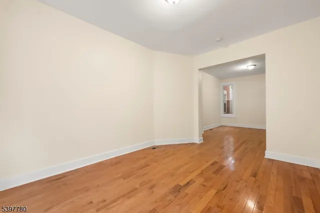 a view of an empty room and wooden floor