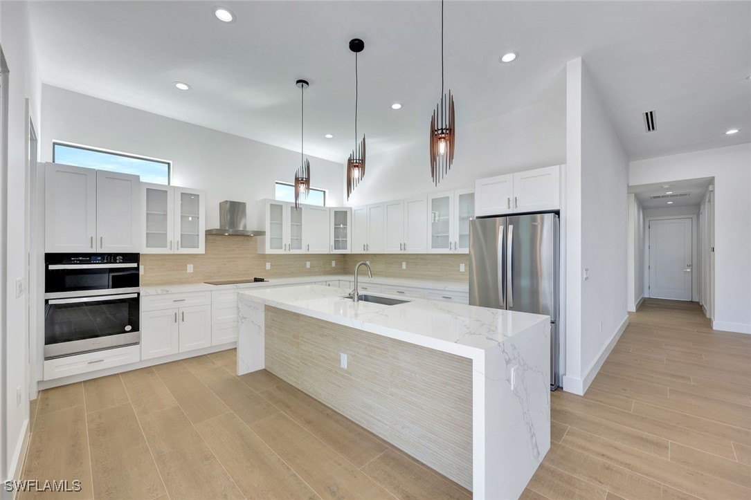 1 Southwest 33rd Place Cape Coral, FL 33991 - Photo 11 of 38 a large kitchen with a large counter top a sink stainless steel appliances and cabinets