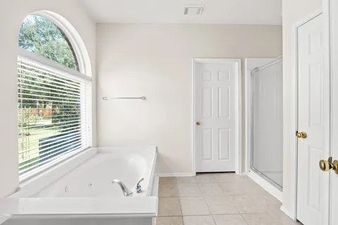 a bathroom with a tub sink and mirror