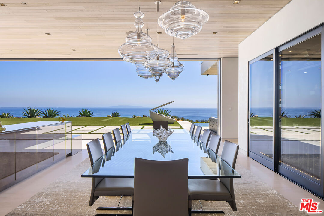 5046 Carbon Beach Terrace Malibu, CA 90265 - Photo 17 of 75 a view of a dining room with furniture a chandelier and wooden floor