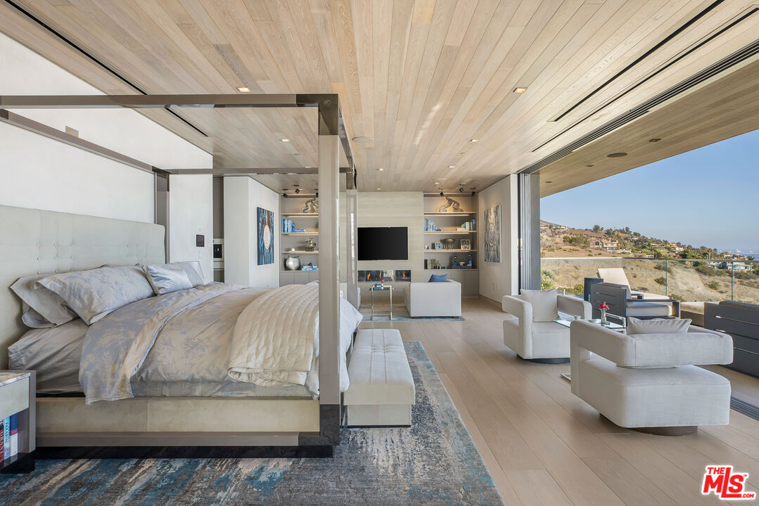 5046 Carbon Beach Terrace Malibu, CA 90265 - Photo 34 of 75 a spacious bedroom with a large bed and a balcony
