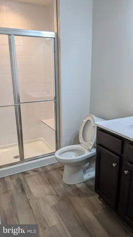 a kitchen with stainless steel appliances granite countertop a sink a stove a refrigerator and island with wooden floor