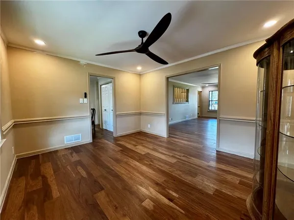 a view of a room with wooden floor staircase and a kitchen