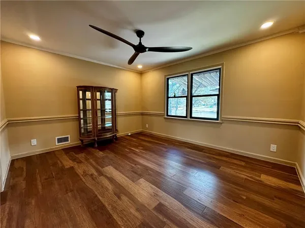 an empty room with wooden floor and windows