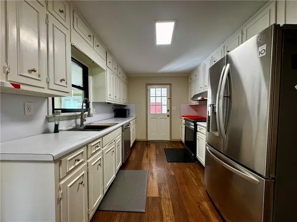 a kitchen with stainless steel appliances granite countertop a refrigerator a stove and a sink