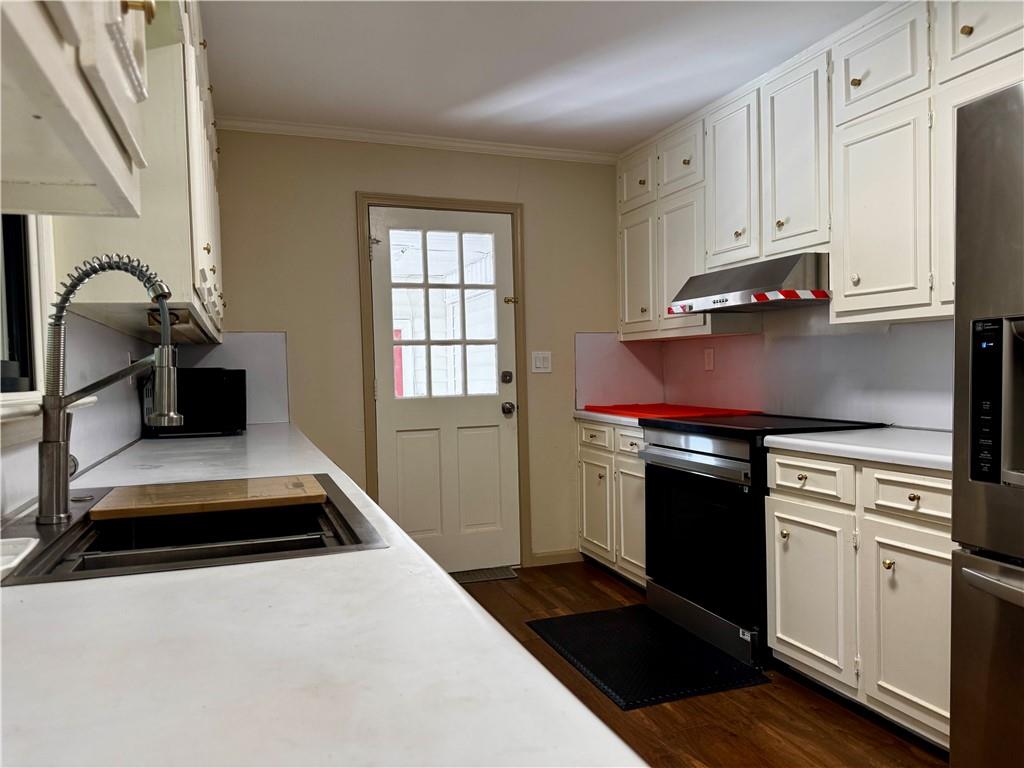 1709 Rangewood Drive Southwest Lilburn, GA 30047 - Photo 20 of 52 a kitchen with stainless steel appliances granite countertop a sink stove and cabinets