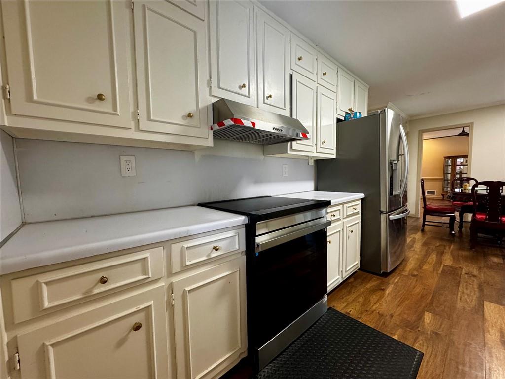 1709 Rangewood Drive Southwest Lilburn, GA 30047 - Photo 21 of 52 a kitchen with stainless steel appliances white cabinets and a refrigerator