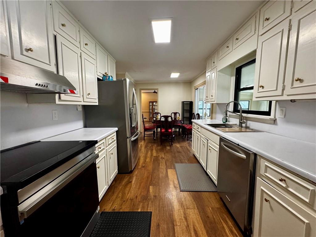 1709 Rangewood Drive Southwest Lilburn, GA 30047 - Photo 22 of 52 a kitchen with stainless steel appliances a stove refrigerator sink and cabinets