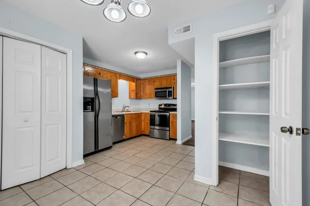 a kitchen with stainless steel appliances granite countertop a refrigerator and a sink