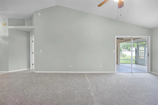 en empty room with windows and chandelier