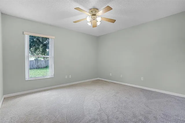 an empty room with closet and a chandelier fan