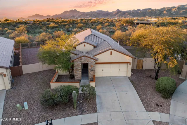 a view of a house with a yard and a large tree